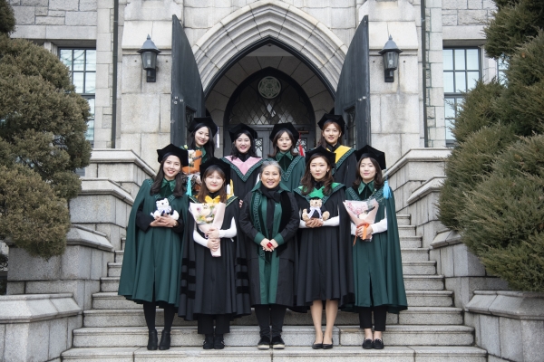 Ewha students are smiling brightly wearing the new graduation gowndesigned by professor Park Sun-hee. Photo provided by Park Sun-hee.