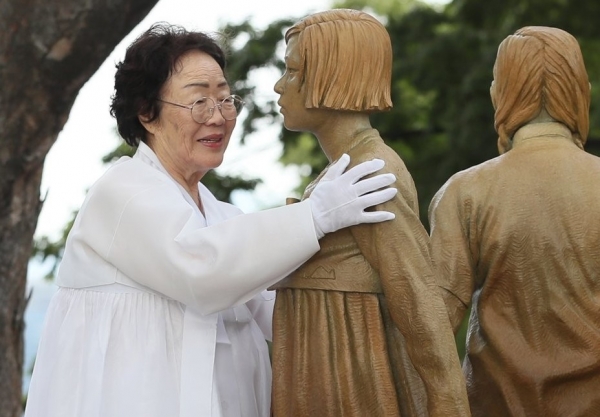 Former comfort woman and current human rights activist, Lee Yong-Soo, touches the Statueof Peace. Photo provided by Yonhap News.