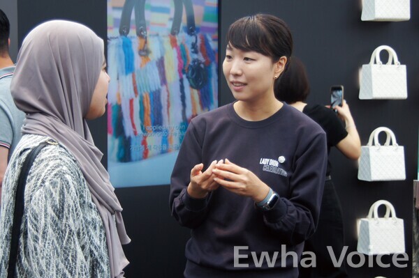 Lee Jeonglim, an Ewha docent and graduate school student majoring in color design technology, explains the artworks to visitors. Photo by Sohn Chae Yoon