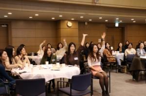 Ewha Voice alumnae raising their hands to answer quizzes about Ewha Voice during homecoming ceremony. Photo by Heo Sol.