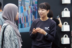 Lee Jeonglim, an Ewha docent and graduate school student majoring in color design technology, explains the artworks to visitors. Photo by Sohn Chae Yoon